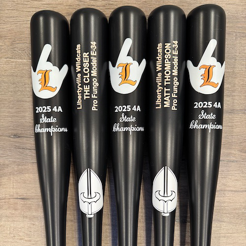 Five black custom Caliburn fungo bats with Libertyville Wildcats logos, personalized coach lettering, and white lettering celebrating the 2025 4A State Champions.