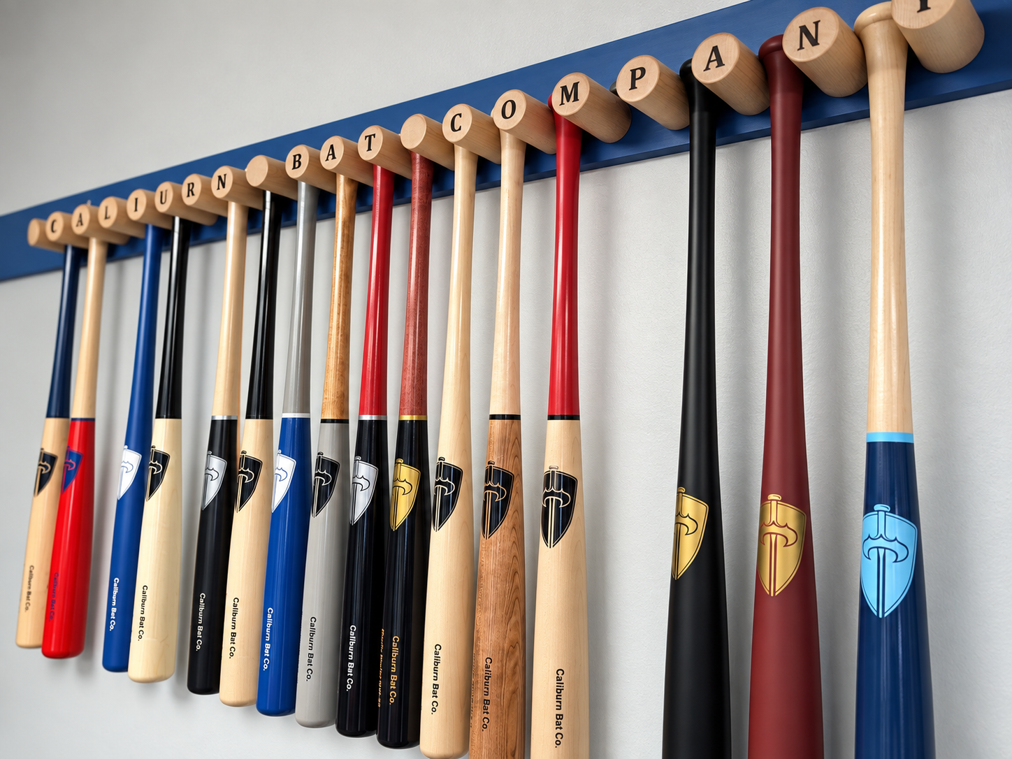 Rack of Caliburn bats hanging below a knob-spelled Caliburn Bat Company sign